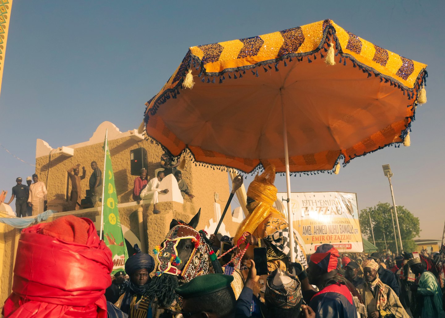 People in traditional clothing gather for an outdoor cultural procession.